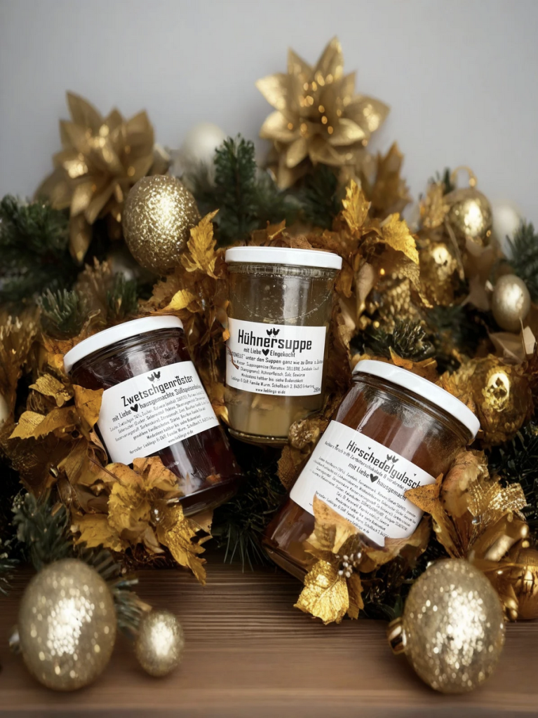 Auswahl regionaler Erntebox Produkte zu Weihnachten mit Hühnersuppe Hirschgulasch und Zwetschgenröster festlich arrangiert